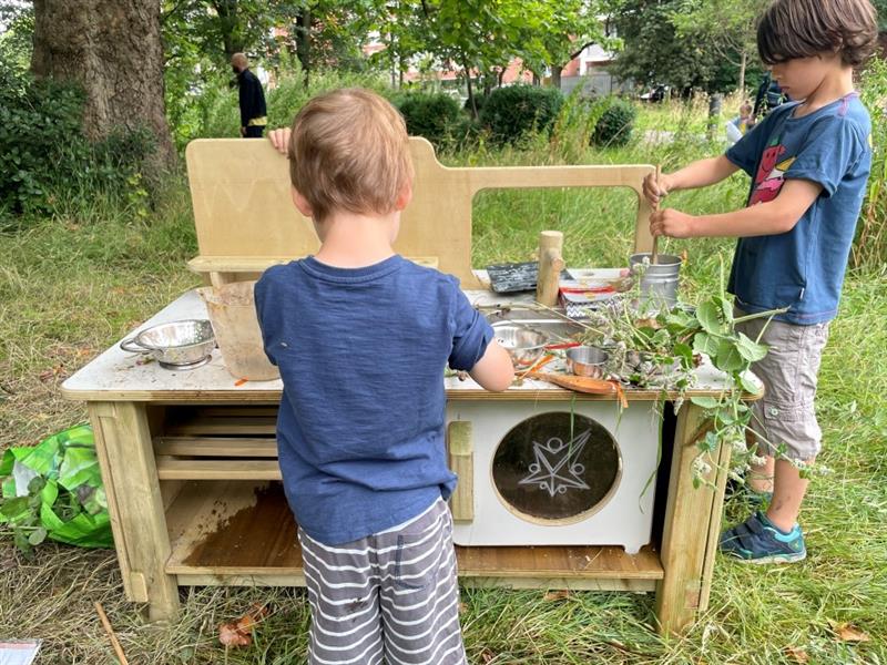 two little boys play with the new mud kitchen at the whitworth art gallery