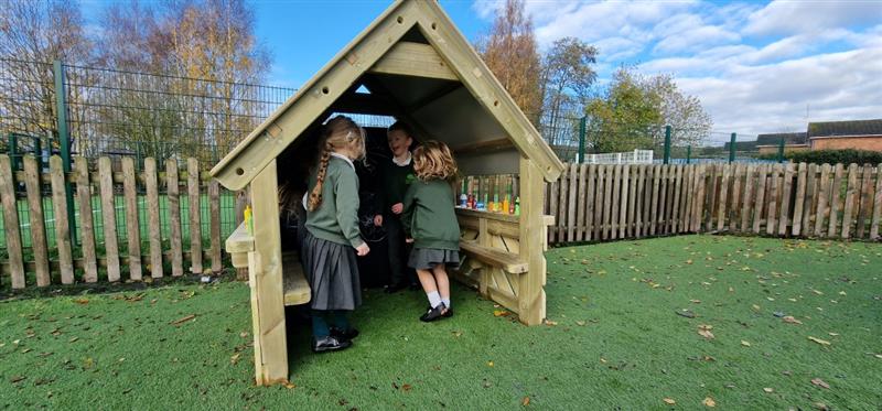 children stand in the playhouse and chat to one another