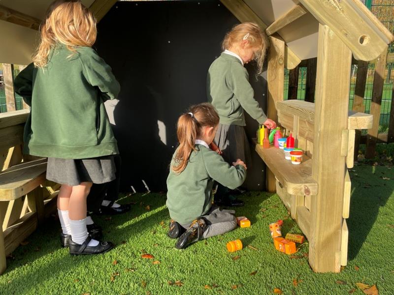 children stand inside the playhouse and build a little shop area