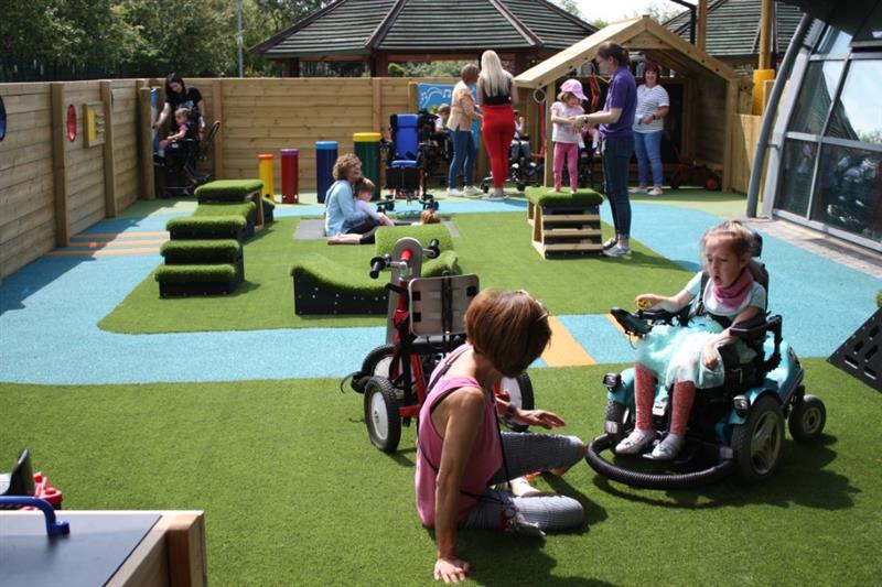 children and practitioners playing in their new, purpose built playground for children with sen