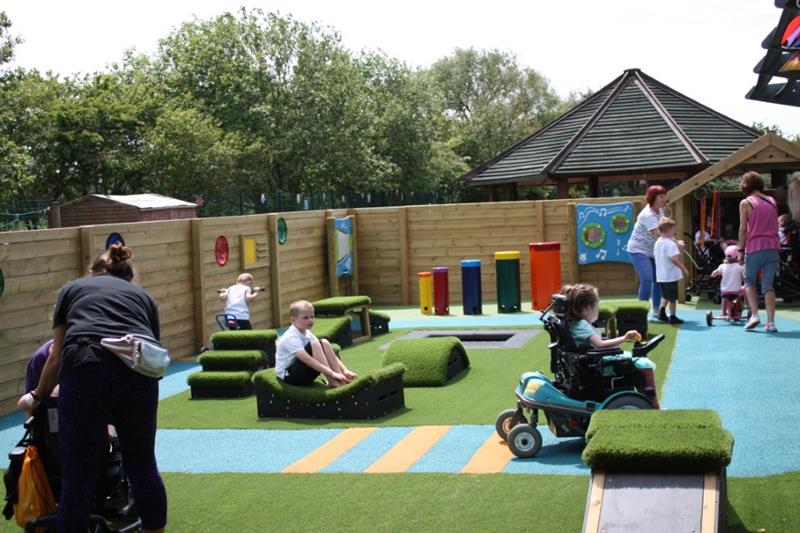 children and practitioners playing in their new, purpose built playground for children with sen