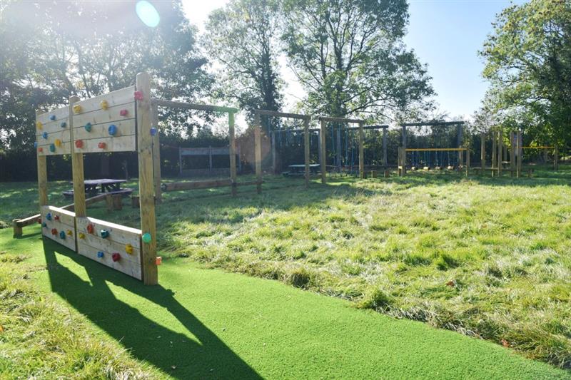 A trim trail installed onto artificial grass surfacing onto a school field
