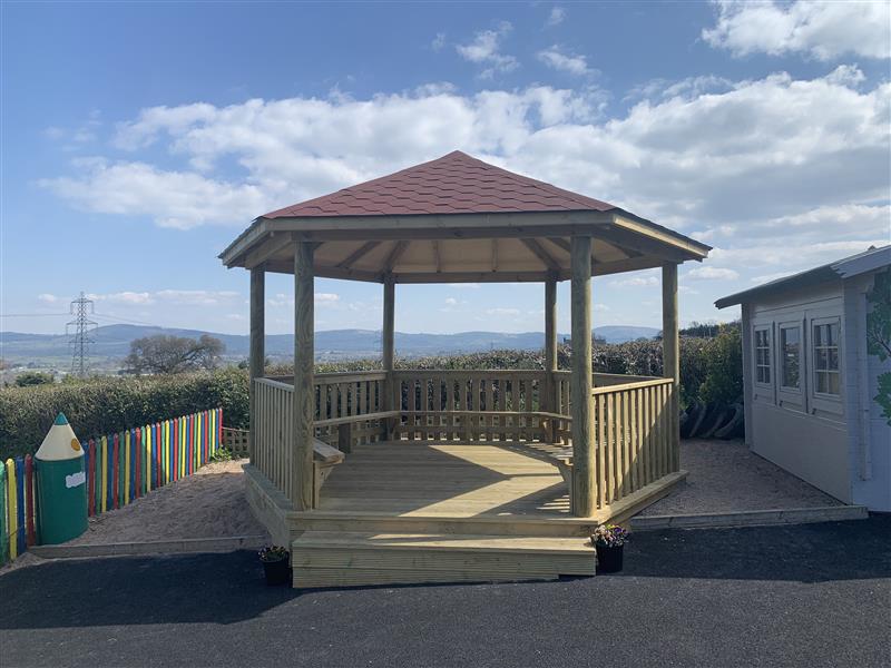 A gazebo with benches and fencing around