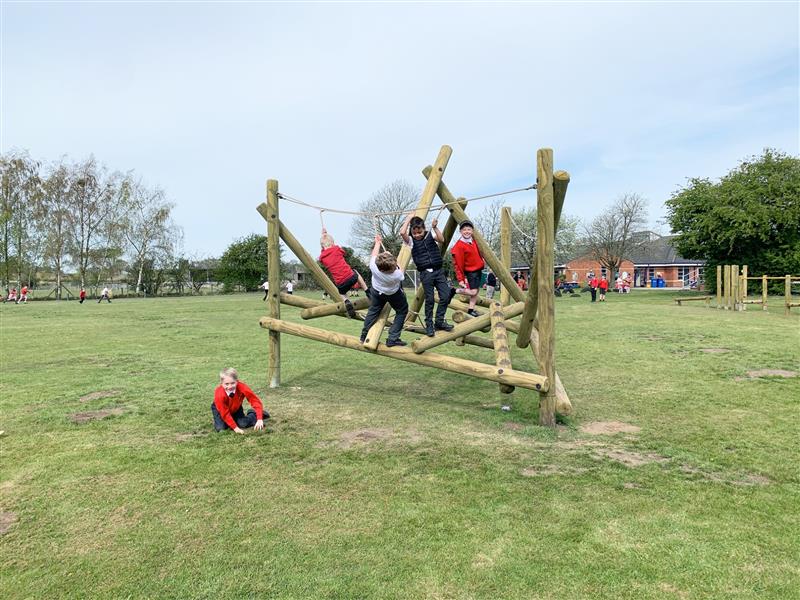 A group of school children playing on a climbing frame