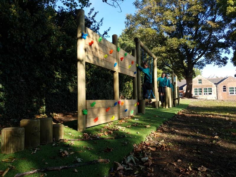 Children playing on a trim trail located underneath a tree