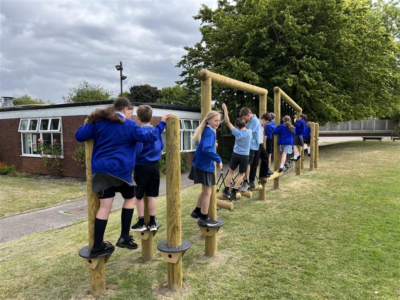 A side view of a ks2 trim trail in their school playground