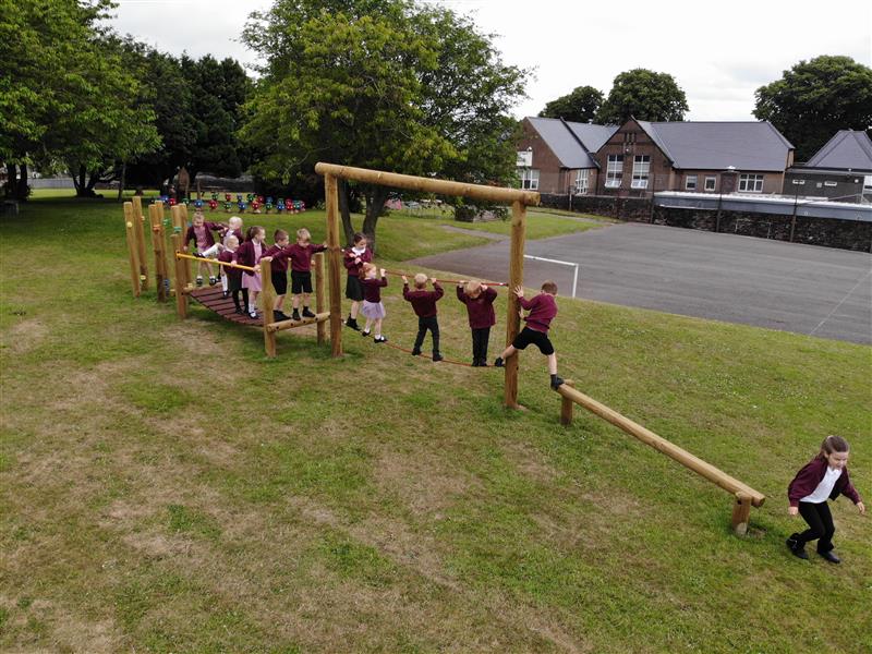 the trim trail at Aspatria primary school, a class of children are going across the trim trail one at a time.