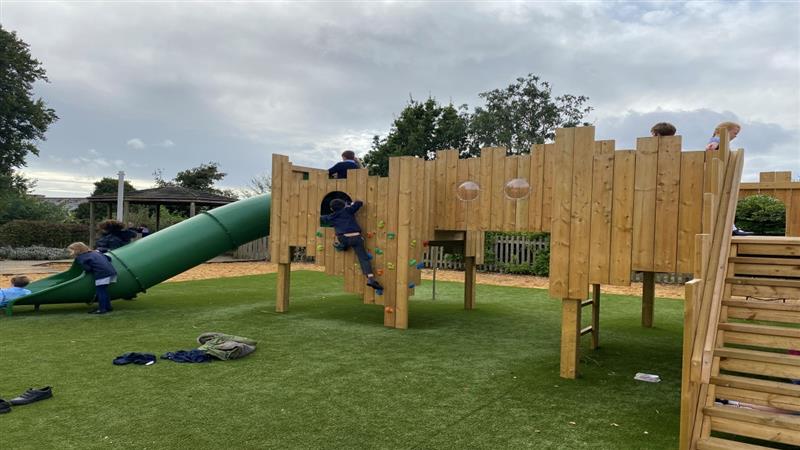 children run around and jump on the timber play castle