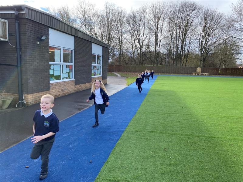 children race along the navy sports carpet track