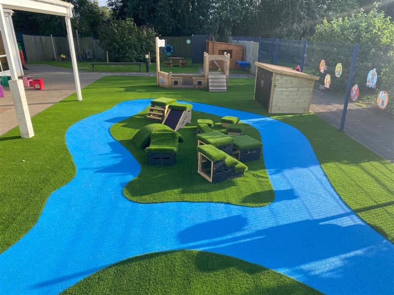 a blue wetpour roadway installed with artiicial grass