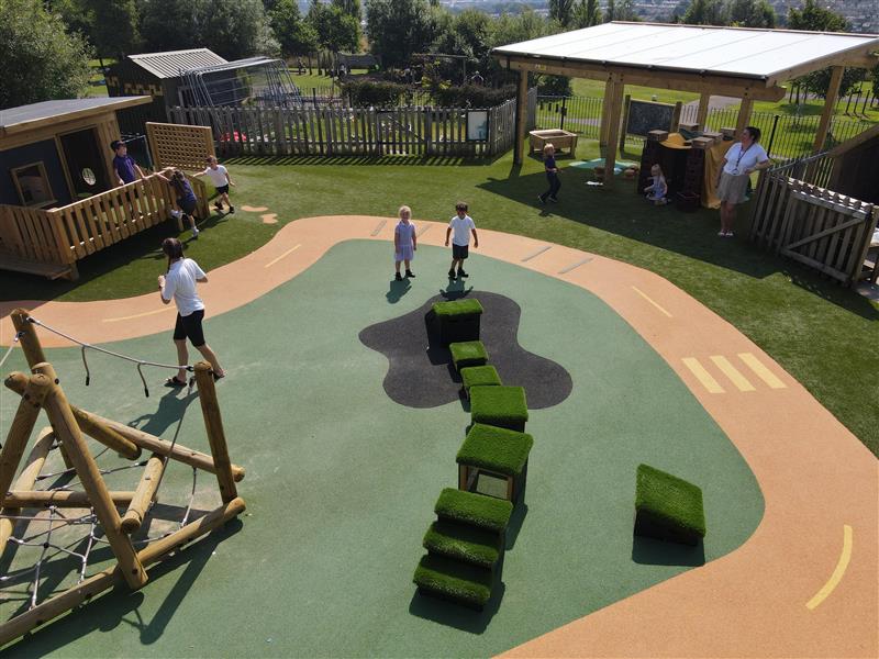 A birds eye view of the playground, two children are stood looking up on the Wetpour
