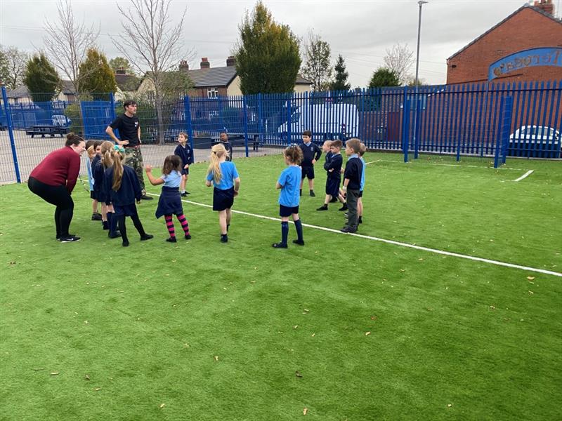 children in blue and black pe equipment take part in a pe lesson the new muga pitch