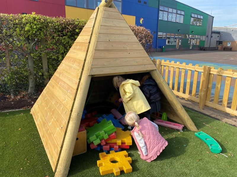 children run and sit in the wigwam whilst they find some toys to play with that are stored in there