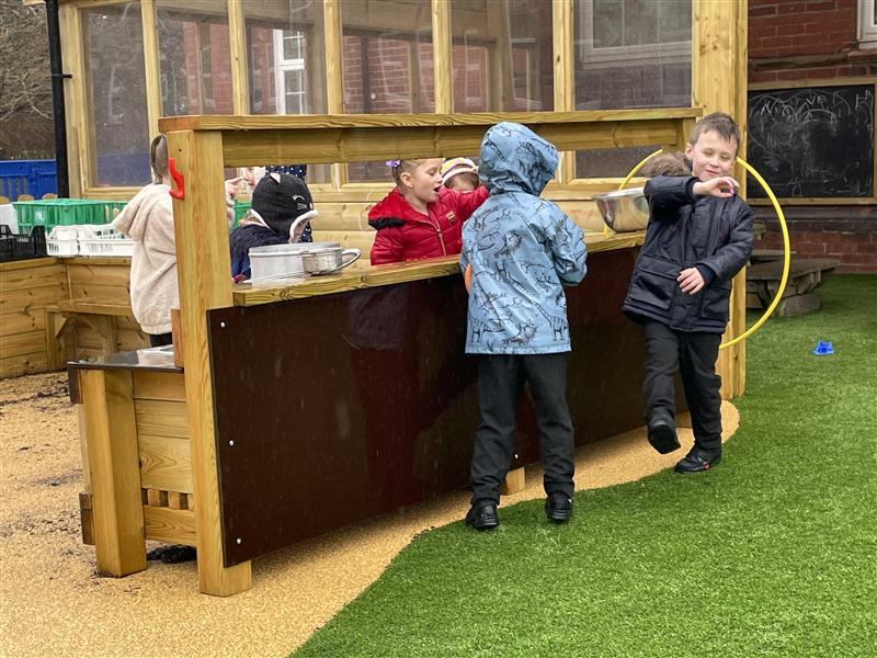 A class of children on the mud kitchen 