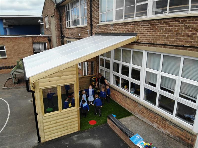 children sit in the brand new canopy on the new artificial grass