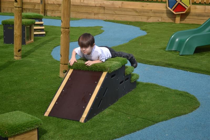 A Birdseye view of a little boy climbing on a Active Block.