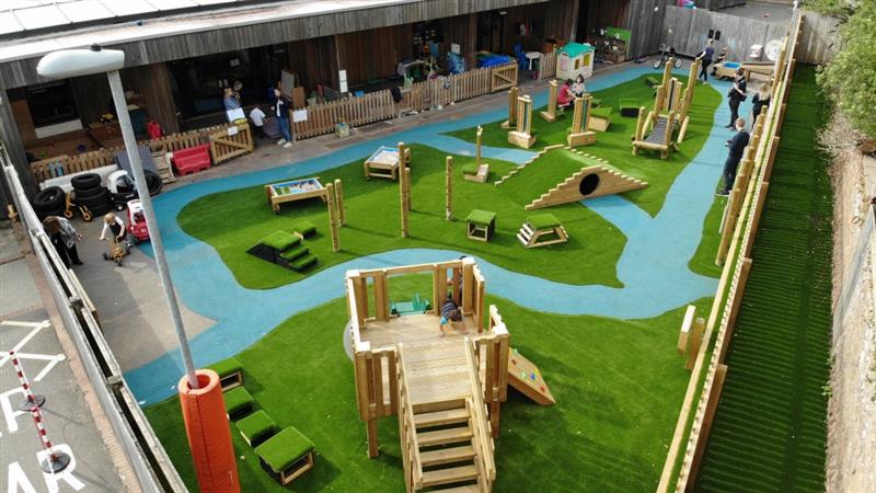 a corner shot of the entire sen play area with green surfacing and play tower