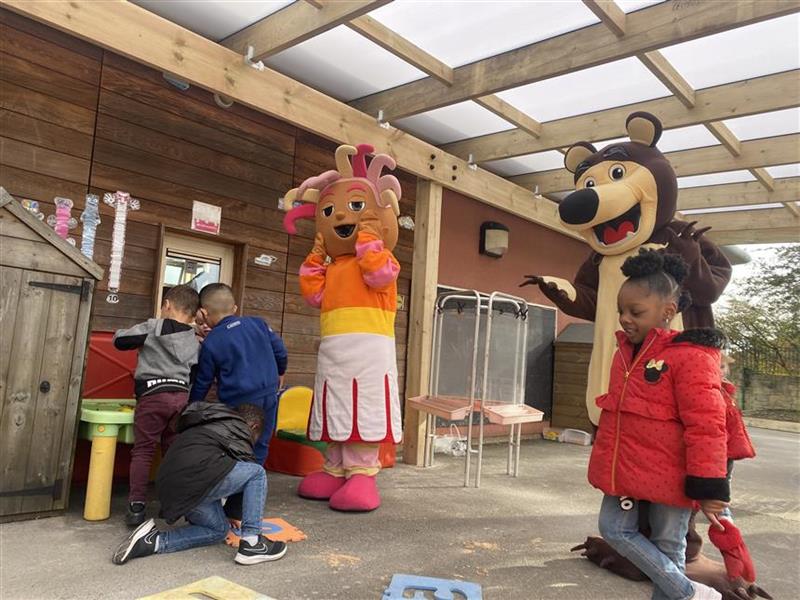 two mascots and 4 children are playing underneath a timber canopy.