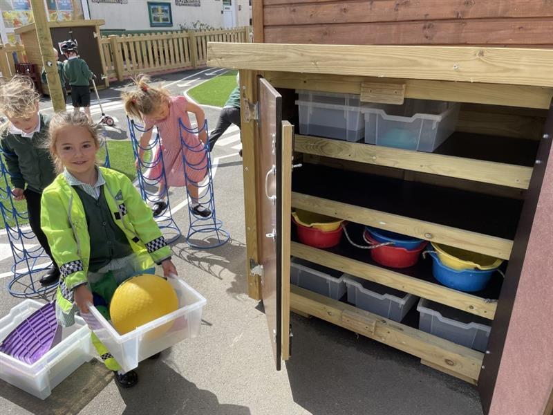 children pack away their resources into their new timber storage unit