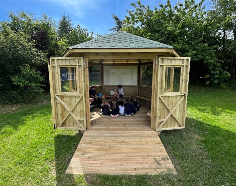 a view into the interior of the outdoor classroom showing the children using the space