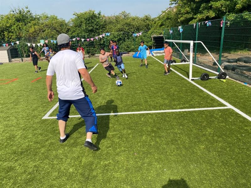 children play football on the new muga 