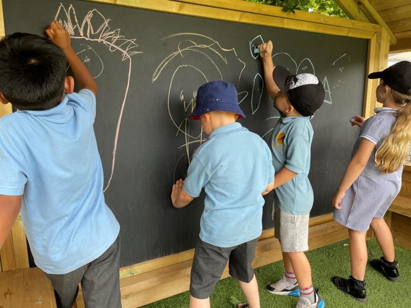children draw on the chalkboard on the inside of the giant playhouse