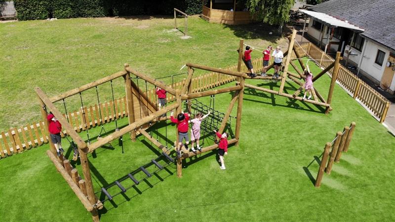 a birdseye view of the wooden climber with children playing happily on it