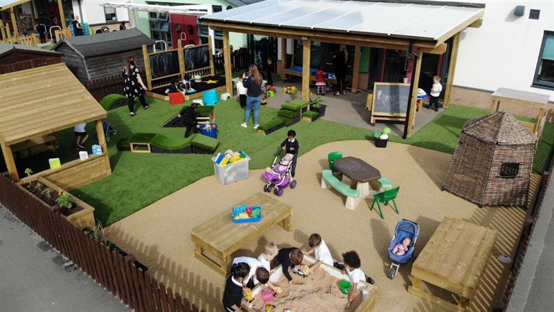 a birdseye view of the orchid vale eyfs area with the sandpit and play house