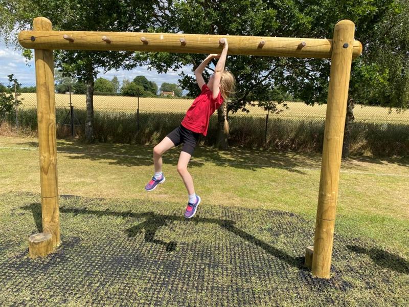 a girl scales the monkey bars