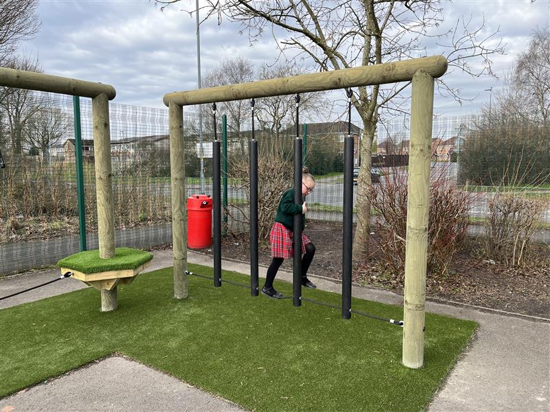 A young girl playing on the trim trail in their playground!