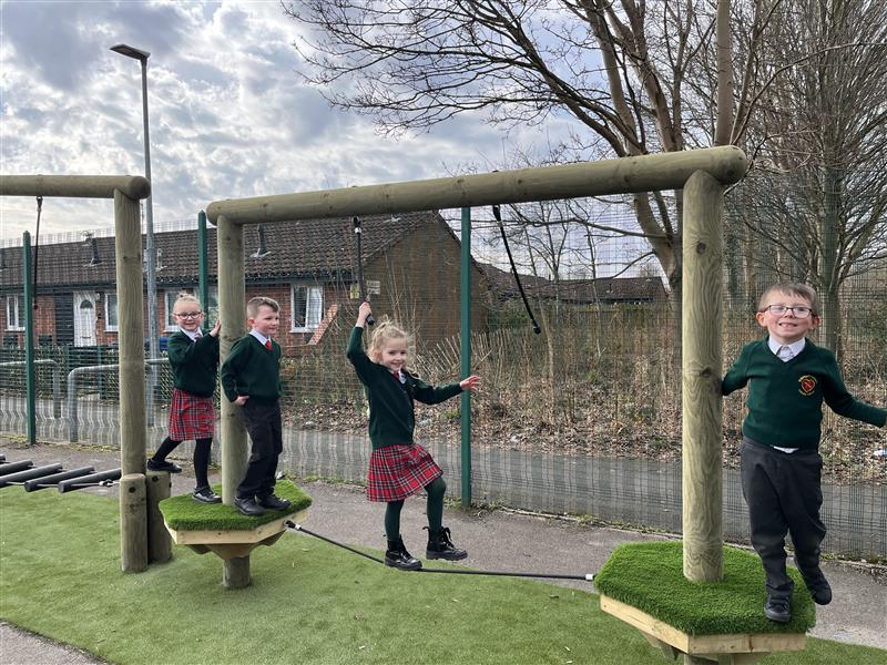 4 children balancing on the tight rope in their playground!