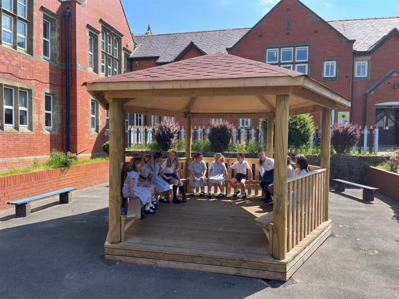 a shot of the gazebo with children inside smiling at the camera