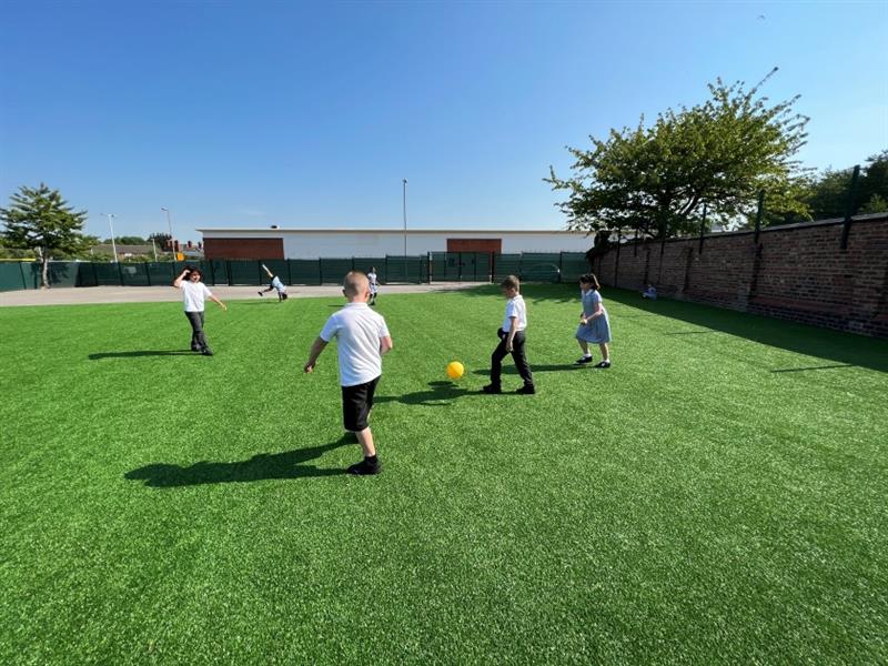 children play on their new artificial grass playing football