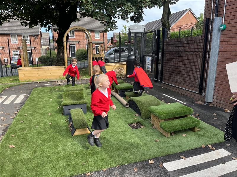 A class of children playing on the blocks in their playground