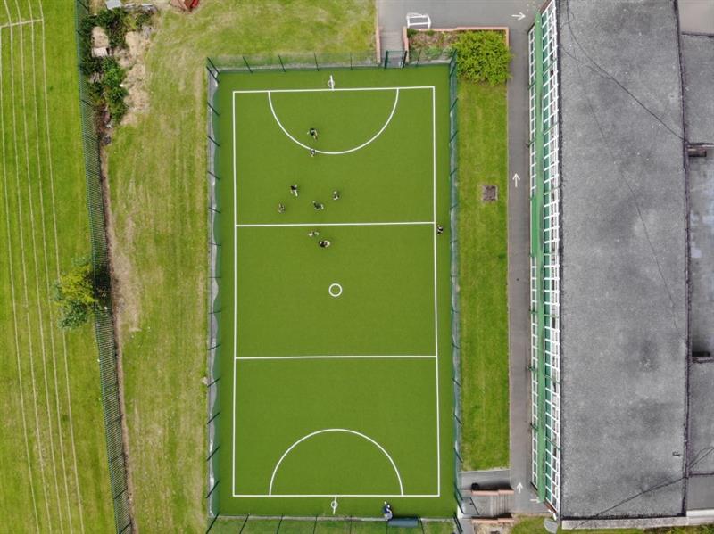 a birdseye view down onto the green sports pitch with white line markings 