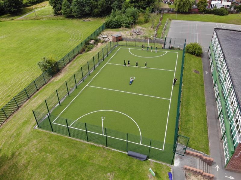 the school installed a large muga with green fencing and green artificial grass surfacing