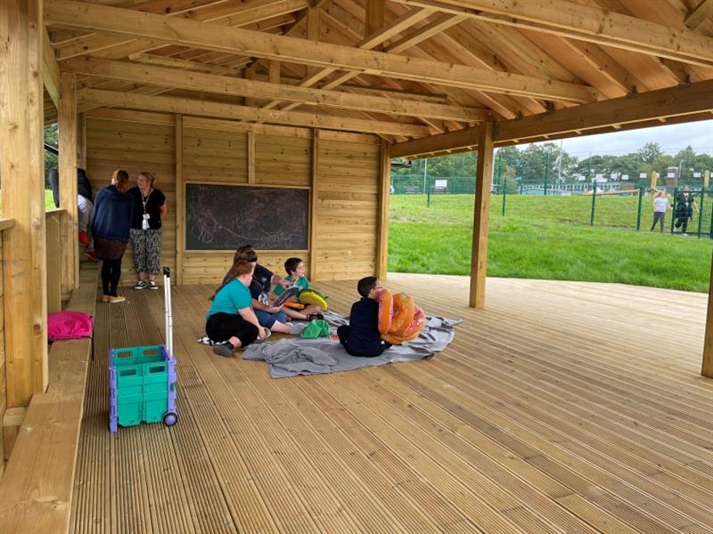 children sit on the floor within the gable end classroom
