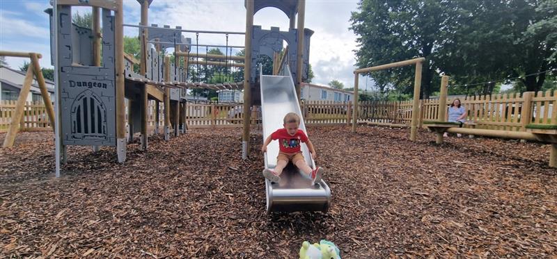 a shot of a child sliding down the slide on the new brynteg play tower