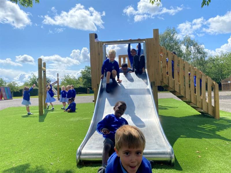 children slide down the large inclusive slide