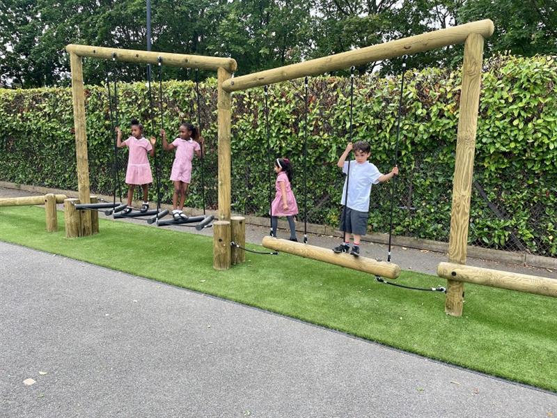 children cross the wobbly log traverse building their strength and coordination