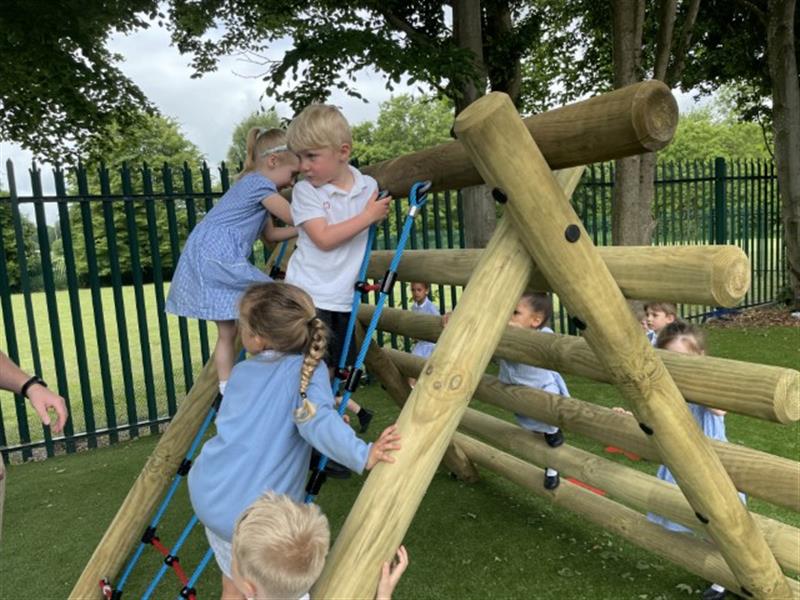 6 children playing on a log and net climber installed onto their school playground