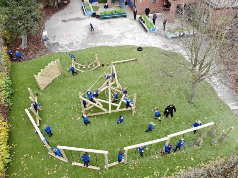 Children playing on a pentagon play forest trim trail