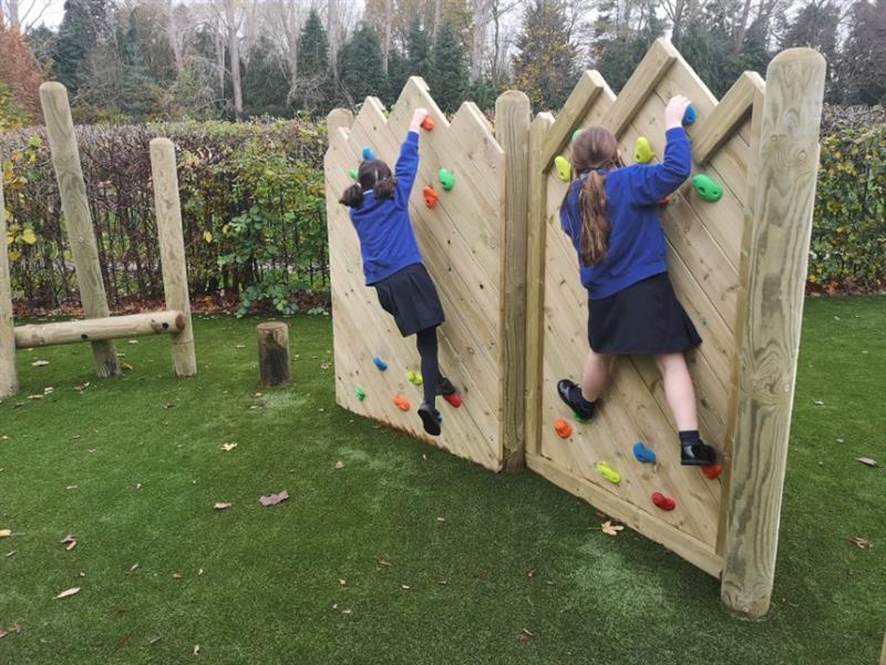 2 children climbing on a pentagon play forest trim trail climbing wall