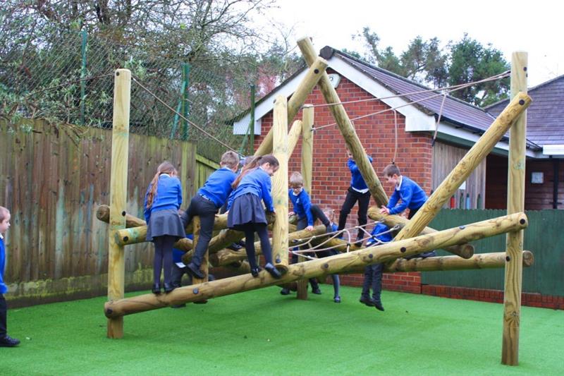 children playing on Pentagon Play's Tryfan Climbing Frame installed onto artificial grass on their school playground