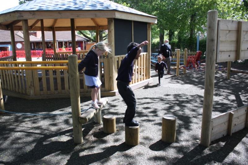 children balancing on stepping logs apart of a trim trail challenge 