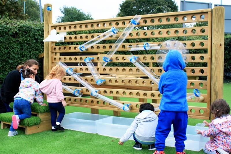 water wall being played with by the children as they try to navigate the way the water falls