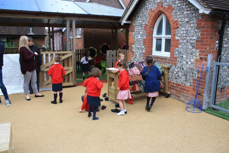 Children putting on raincoats and wellies