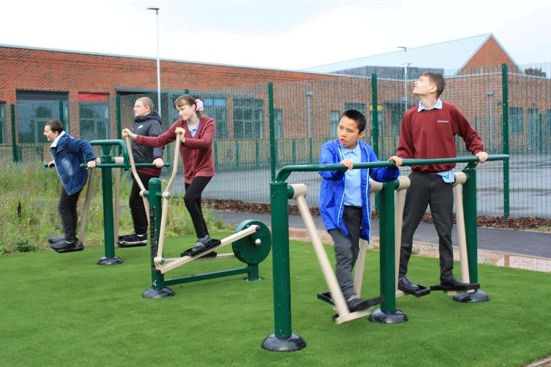 children play outdoors on outdoor gym equipment 
