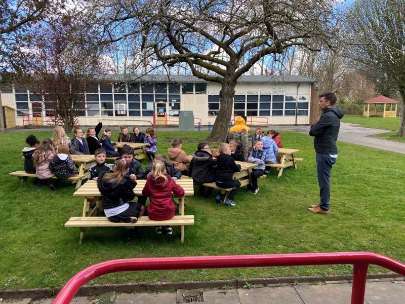 a picture of 6 picnic tables all gathered together as a class have a picnic