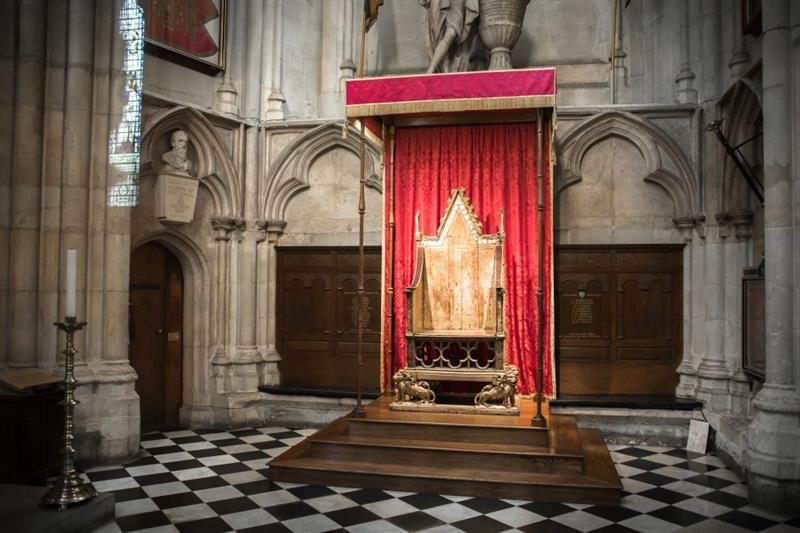 a shot of the coronation chair in a red curtained box 